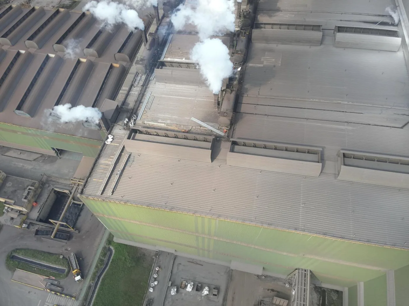 Aérea da planta com a fachada verde e colunas de vapor sobre a cobertura
